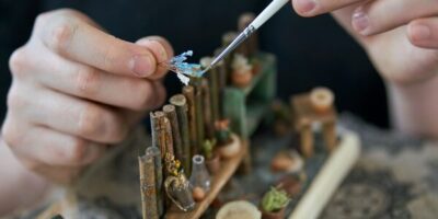 des mains d'adolescent en train de réaliser un diorama