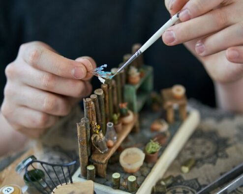 des mains d'adolescent en train de réaliser un diorama