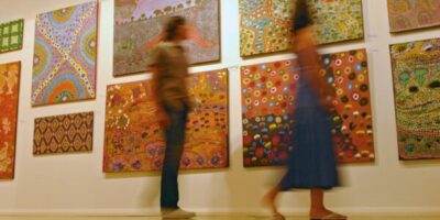 deux personnes visitent une exposition de peinture