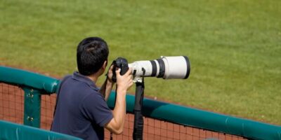 un photographe au bort d'un terrain de sport